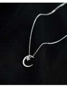 Detailed close-up of 925 sterling silver moon and star pendant with sparkling zircon stones