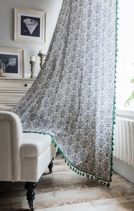 Detail of vintage blue pattern curtain with green tassels on cotton-linen fabric