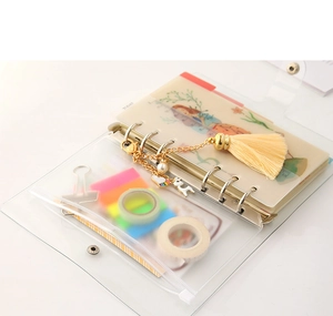 Detail van transparante PVC A5-map met zilveren 6-rings clips en decoratieve kwastjeshanger