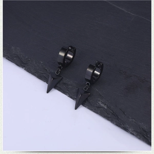 Macro view of black stainless steel earrings featuring geometric cone spikes and hoops