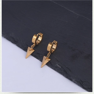 Detail view of golden stainless steel hoop earrings featuring sharp triangular pendants