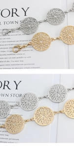 Detail of metal link chain belt with hollow circular patterns in gold and silver finish