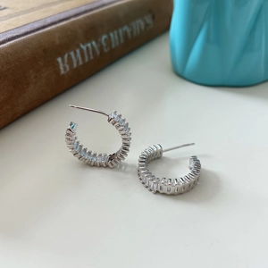 Detail shot of silver C-shaped stud earrings with rectangular baguette-cut cubic zirconia stones