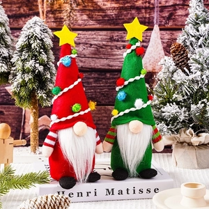 Christmas gnome dolls with red and green hats standing on a decorative holiday scene