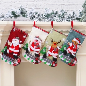 Set of 4 linen Christmas stockings with plaid patterns hanging on a fireplace mantel