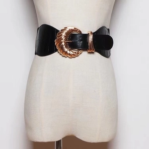 Detail of black wide belt with crocodile pattern PU leather and golden shell buckle