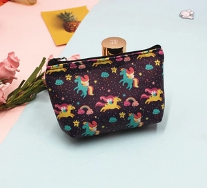 Detail of purple unicorn coin purse with rainbow patterns on pink and blue background