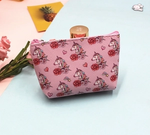 Detailed view of pink unicorn makeup pouch with floral patterns and shell-shaped structure