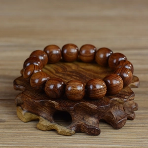 Vue macro des perles en bois de poirier 15mm avec grain naturel sur support en bois