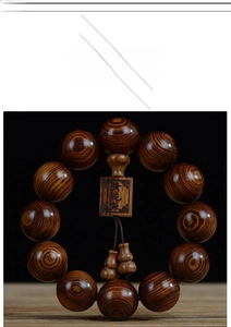 Vue macro de 12 perles en bois Dalbergia odorifera avec rayures de tigre et petits pendentifs