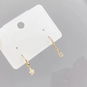 Asymmetric gold earrings set with micro-pave cubic zirconia petals and safety pin design