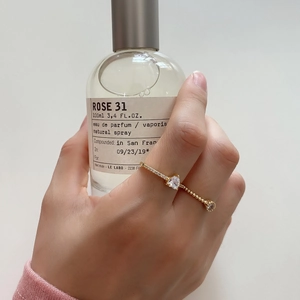Minimalist 925 silver ring with zircon stones shown on hand with perfume bottle