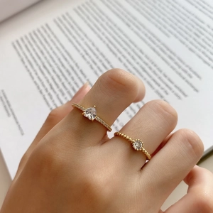 Close-up of a 925 sterling silver heart-shaped zircon ring set on a book background