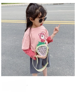Detail of glitter strawberry crossbody bag with sequins paired with pink Lotso graphic shirt