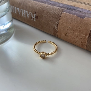 Detail of 925 silver beaded open ring with sparkling zircon stone in gold finish