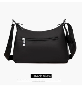 Rear view of black nylon crossbody bag showing the functional silver back zipper pocket
