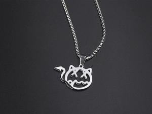 Macro detail of silver little devil pendant with X-eyes on a polished box chain