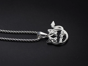 Detailed view of silver titanium steel devil cat pendant with X-shaped eyes and tail