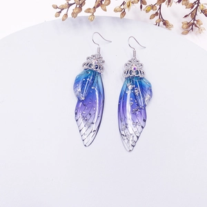 Detailed view of butterfly wing earrings with blue-purple gradient and silver foil inlay
