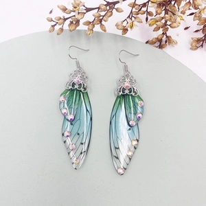 Detailed macro of gradient green cicada wing earrings with rhinestones and silver hooks