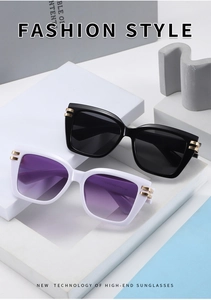 Detail view of square fashion sunglasses with gold metal hinges and purple gradient lenses