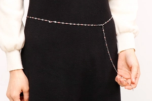 Gros plan d'une fine chaîne de taille argentée avec de petits cœurs sur une robe
