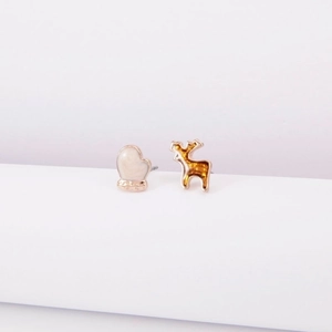 Detail of asymmetric Christmas earrings with a white glove and golden reindeer