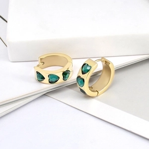 Close-up detail of heart-shaped gold earring with green zircon stone and S925 silver needle