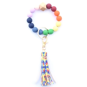 Detail of colorful silicone bead bracelet with wooden bead, golden clasp and PU fringe tassel