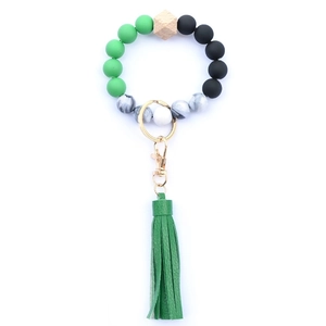 Close-up of green silicone beads with wood hex bead and a faux leather fringe tassel