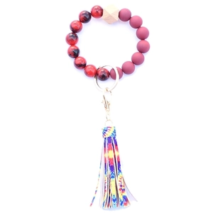 Detail of red wooden bead bracelet keychain with leopard print and colorful tassel