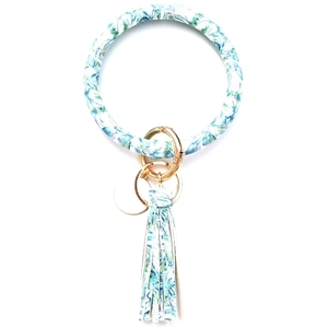 Detail of teal tropical leaf pattern PU leather bangle keychain with golden ring and tassel