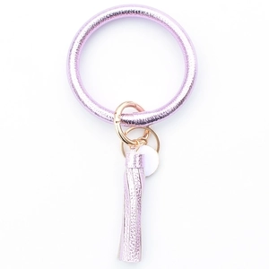 Detail of purple metallic ring keychain with matching tassel and gold hardware accessory