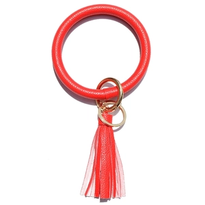 Close-up of red lychee pattern leather keyring with round bangle and tassel detail