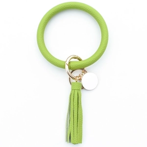 Detail of lime green pebble grain PU leather wristlet keychain with tassel and gold ring