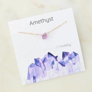 Minimalist gold chain necklace featuring irregular natural amethyst crystal on display card