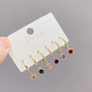 Detalle de seis pares de aros dorados con colgantes de piedras preciosas de colores
