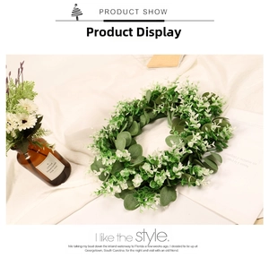 Detail of faux eucalyptus leaves wreath on a white fabric background for home decor