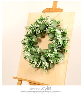 Detail of faux eucalyptus wreath hanging on a wooden easel for rustic home decor