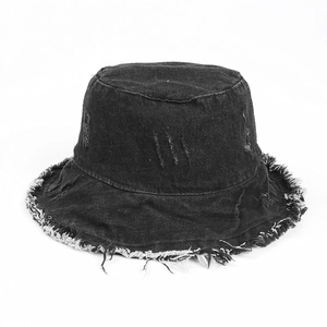 Close-up of frayed edges and distressed details on black washed denim bucket hat