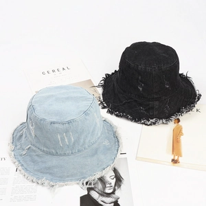 Retro washed denim bucket hat with frayed edges in light blue and black colors