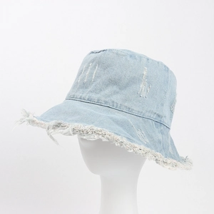 Close-up detail of light blue denim bucket hat with frayed edges and distressed textures