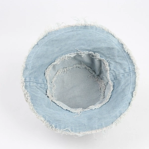 Vintage light blue washed denim bucket hat with distressed frayed edges in a flat lay view