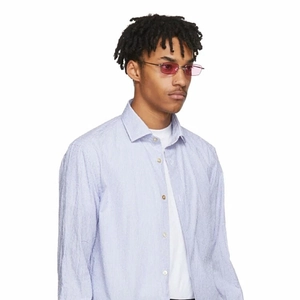 Dettaglio occhiali da sole stretti in metallo con lenti rosa e camicia a righe blu