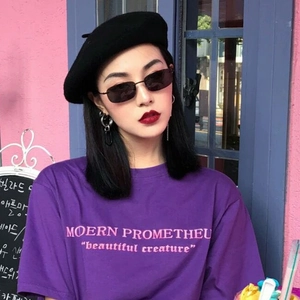 Occhiali da sole neri a montatura stretta indossati da una modella asiatica in stile street