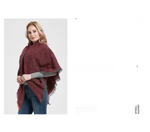 Detail of burgundy knitted winter shawl with dark grey fringe and marled texture