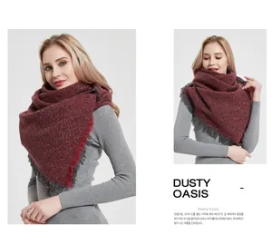 Close-up of thick knitted wine red scarf with dark grey tassel edges for winter warmth