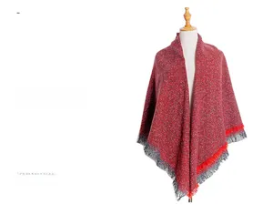 Detail of red and grey knit shawl with fine fringes and thick wool blend texture
