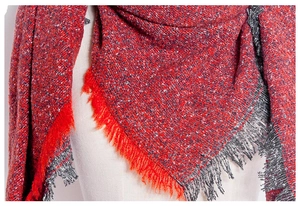 Close-up of red and grey knit scarf with textured fringe details for winter
