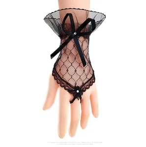 Detail of black lace fingerless gloves featuring a satin bow and rhinestone accents